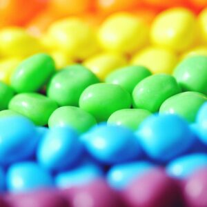 Colorful array of candies in a neat row, creating a rainbow effect.